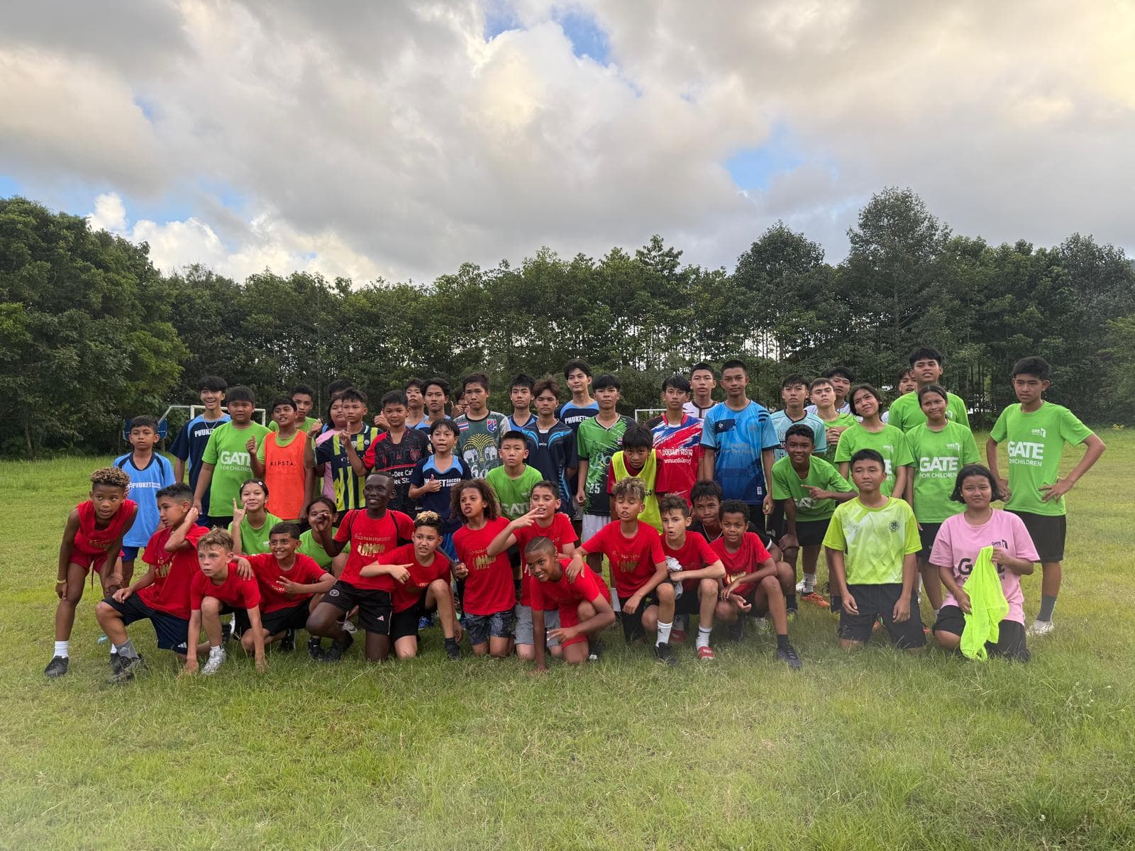 A large group of children and coaches together on the field